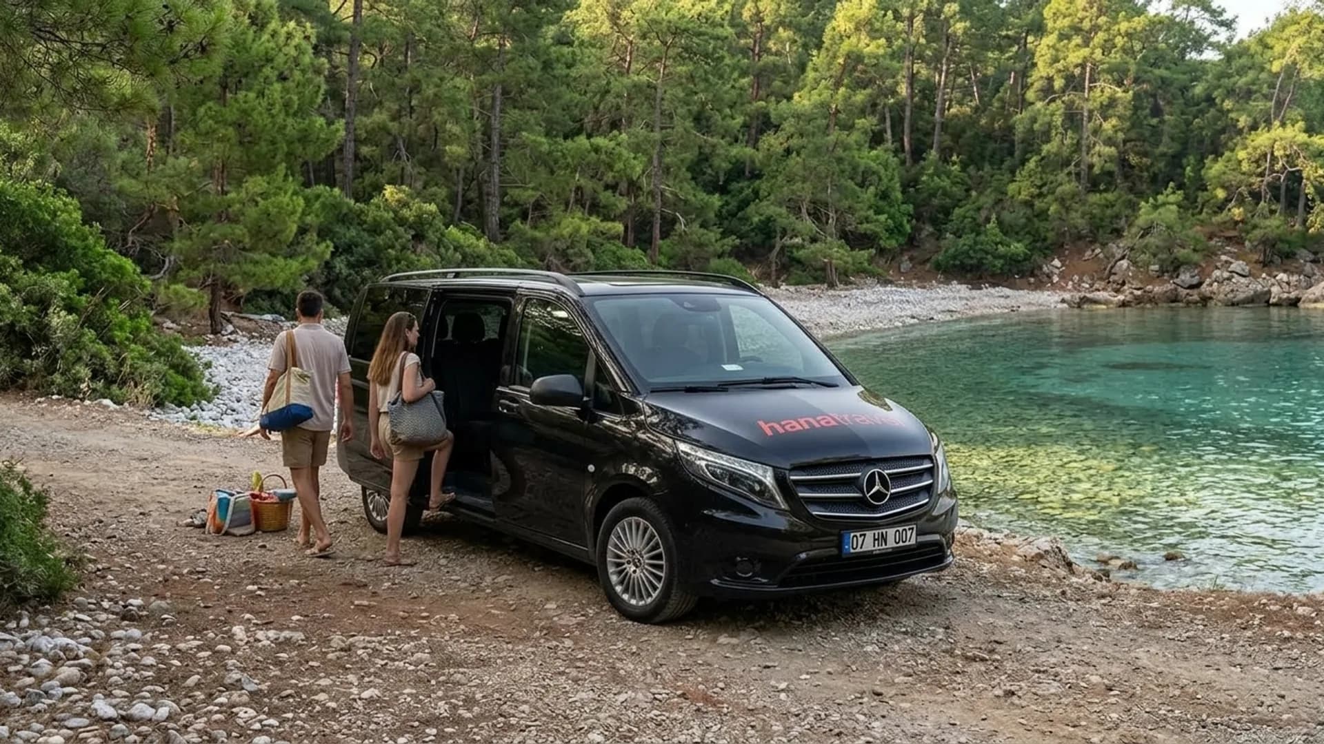 Pinien, Kiesel und klares Wasser bei Phaselis Familie steigt aus dem Hana Travel Van an einer Kieselbucht bei Phaselis, wo der Pinienwald bis ans Wasser reicht – Transfer nach Tekirova ab Flughafen Antalya
