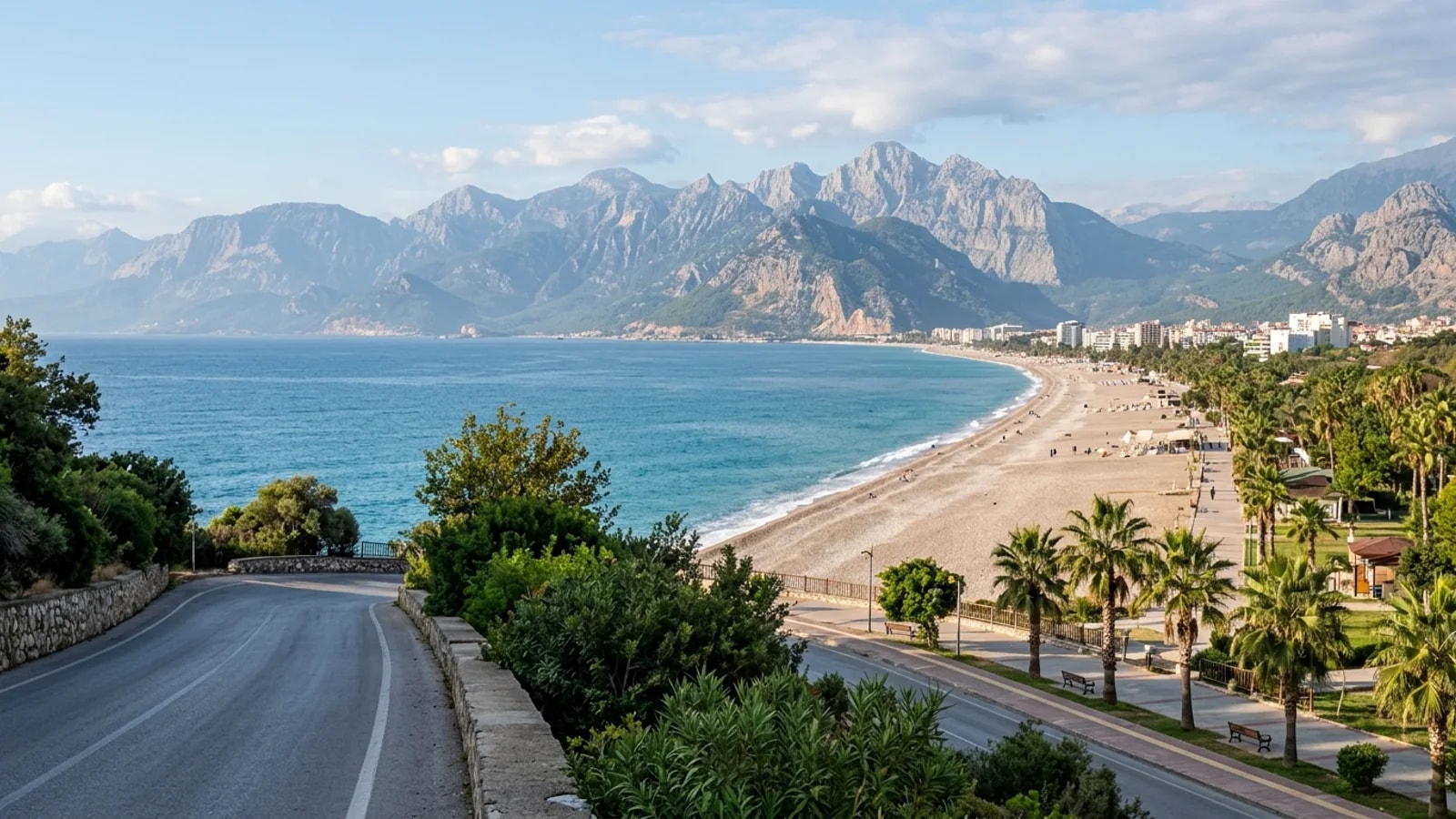 Transfert Konyaaltı depuis l’aéroport d’Antalya – taxi transfert Kemer La longue plage de galets de Konyaaltı s'étend vers les montagnes Beydaglari avec des palmiers, visible en taxi transfert Kemer.
