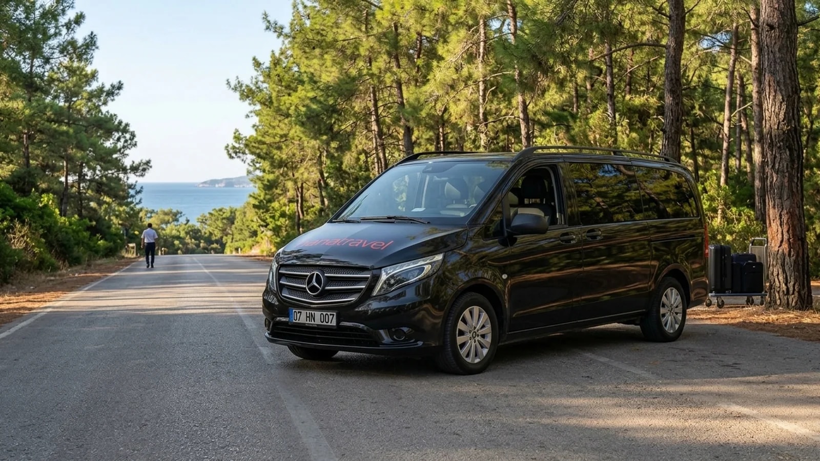 Exploring the Kemer Coast: Pine Forests, Ruins and Flames A black transfer van parked on a quiet road in Tekirova for a reliable Tekirova transfer.